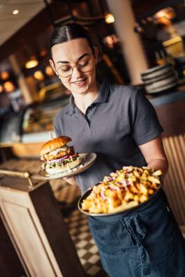 Een burger en loaded fries worden geserveerd